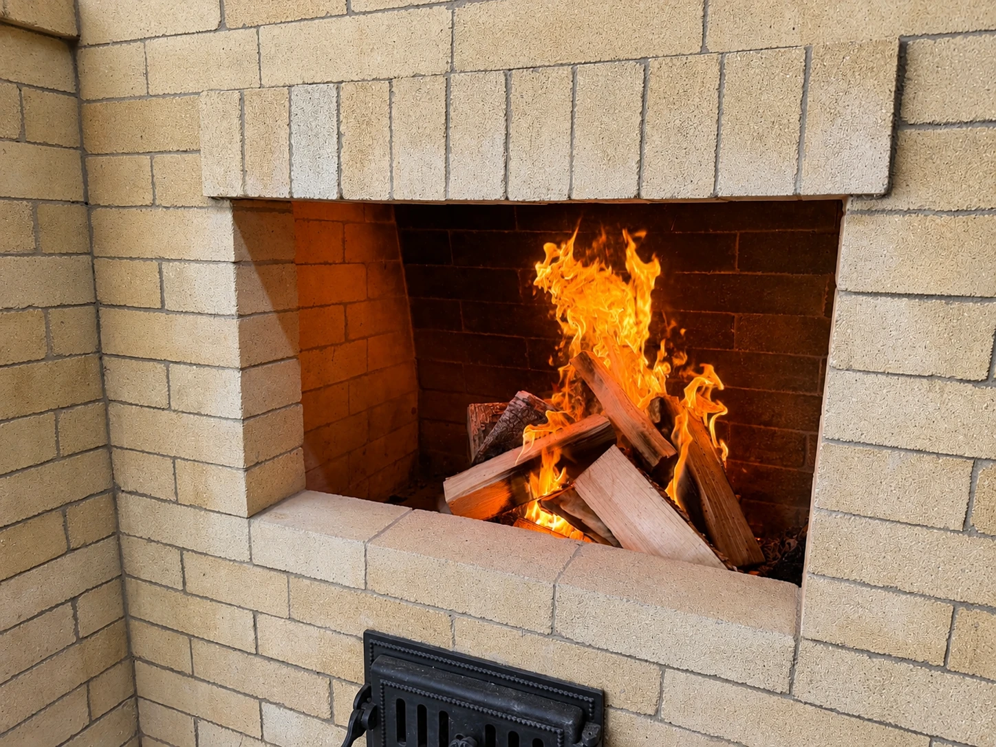 Открытый кирпичный мангал с горящими дровами